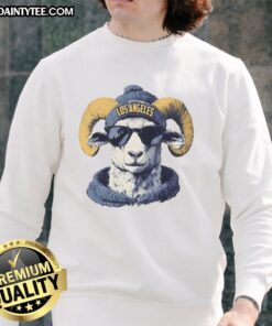 Awesome Los Angeles Rams mascot in a beanie and sunglasses, wearing a stylish sweatshirt at a game day event.