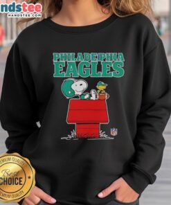 Awesome Philadelphia Eagles Snoopy chilling with a football in Peanuts style sweatshirt, perfect for fans.