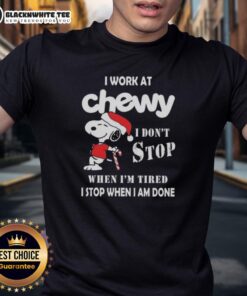 Alt Text: Awesome Snoopy Christmas T-shirt with 'I Work At Chewy I Dont Stop When Im Tired' slogan for dog lovers.