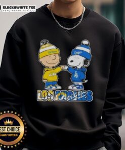 Cute Charlie Brown fist bump with Snoopy on Los Angeles Sports Rams x Dodgers sweatshirt, perfect for fans.