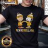 Alt Text: Cute Charlie Brown and Snoopy fist bump on Pittsburgh Steelers and Penguins T-shirt, perfect for city sports fans.