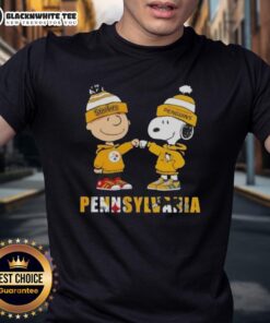 Alt Text: Cute Charlie Brown and Snoopy fist bump on Pittsburgh Steelers and Penguins T-shirt, perfect for city sports fans.