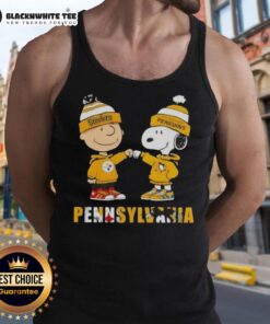 Adorable Charlie Brown fist bumping Snoopy in a Pittsburgh Steelers and Penguins tank top, showcasing city sports pride.