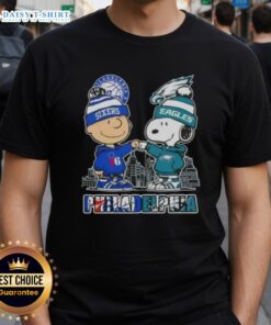 Cute Charlie Brown fist bump with Snoopy on Philadelphia 76ers x Eagles skyline T-shirt, perfect for sports fans.
