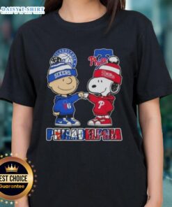 Cute Charlie Brown fist bump with Snoopy, featuring Philadelphia City Sports 76ers x Phillies ladies tee design.
