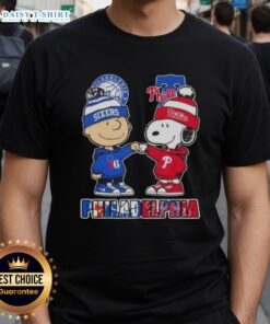 Alt Text: Cute Charlie Brown and Snoopy fist bump on Philadelphia sports T-shirt featuring 76ers and Phillies logos.