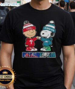 Alt Text: Cute Charlie Brown and Snoopy fist bump on a Philadelphia City Sports t-shirt featuring Phillies and Eagles design.
