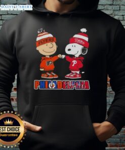 Cute Charlie Brown fist bump with Snoopy in Philadelphia sports hoodie featuring Phillies and Flyers designs.