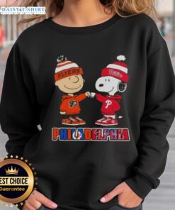 Cute Charlie Brown and Snoopy fist bump in Philadelphia sports sweatshirt featuring Phillies and Flyers logos.