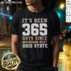 Funny 'It's Been 365 Days Since Michigan Beat Ohio State' T-Shirt featuring bold text and team colors for fans.