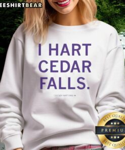 Good Cassidy Hartman I Hart Cedar Falls sweatshirt displayed on a wooden background, showcasing its stylish design.