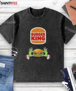Good Grinch hands holding a Merry Christmas Burger King washed t-shirt, perfect for festive holiday cheer and style.
