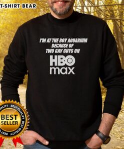 Man wearing 'Good I'm At The Boy Aquarium' sweatshirt, inspired by two gay guys on HBO Max, at a vibrant aquarium.