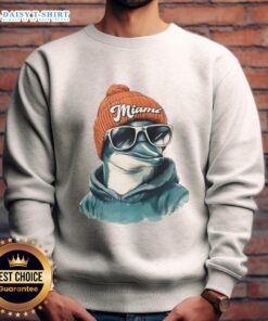 Miami Dolphins mascot wearing a beanie, sunglasses, and a sweatshirt, showcasing team spirit in a fun outfit.