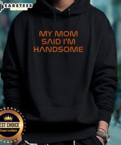 Boy wearing 'Good-My-Mom-Said-Im-Handsome' hoodie, smiling confidently in a bright outdoor setting.