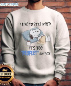 Cozy sweatshirt featuring Snoopy lounging in bed with text 'I Like To Stay In Bed, It's Too Peopley Outside'.