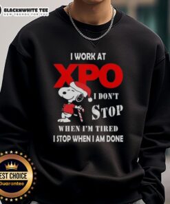 Cozy Christmas sweatshirt featuring Snoopy with 'I work at XPO, I don't stop when I'm tired, I stop when I'm done' quote.