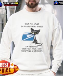 Grumpy USPS woman in a 'Good Tired Cat' sweatshirt, showcasing her fierce attitude and humor in a cozy outfit.