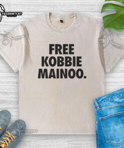 Happy Man United fan wearing a Free Kobbie Mainoo washed t-shirt, celebrating with joy and pride for his brother Kobbie Mainoo.