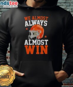 Happy football fan wearing a 'We Almost Always Almost Win' hoodie, showcasing team spirit and humor at a game.