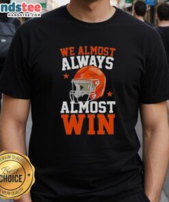 Happy football fan wearing 'Almost Always Almost Win' T-shirt, showcasing humor and team spirit in sports fashion.