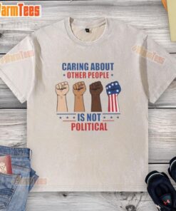 Hot Caring About Other People Is Not Political Fists Washed T-Shirt displayed on a hanger, showcasing its bold message.
