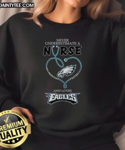 Hot sweatshirt featuring 'Never Underestimate a Nurse Who Loves Football' design for Philadelphia Eagles fans.