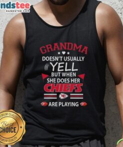 Nice grandma in a Kansas City Chiefs tank top, passionately cheering during a football game, showcasing her playful side.