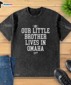 Nice Nebraska Rivalry 'Our Little Brother Lives in Omaha' washed t-shirt displayed on a wooden background.
