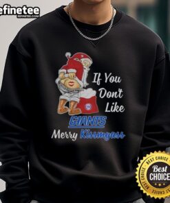 Santa Claus wearing a funny sweatshirt saying 'If You Don't Like New York Giants, Merry Kissmyass' for holiday cheer.