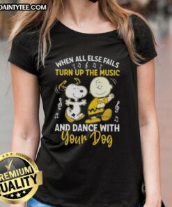 Alt Text: Snoopy and Charlie Brown dancing with a dog, showcasing the 'When All Else Fails, Turn Up the Music' tee design.