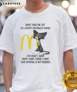 Grumpy cat wearing a McDonald's-themed t-shirt with the phrase 'Don't Piss Me Off, I'm a Grumpy McDonald's Woman.'