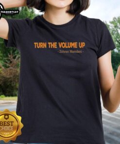 Zohran Mamdani wearing a stylish 'Turn The Volume Up' ladies tee, promoting local pride and community spirit.