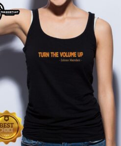 Zohran Mamdani wearing a 'Turn The Volume Up' tank top, showcasing vibrant style and youthful energy.