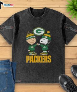 Official Charlie Brown fist bump with Snoopy on a Green Bay Packers washed t-shirt, perfect for fans and collectors.