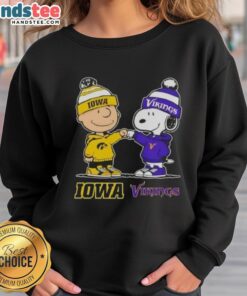 Official Charlie Brown fist bump with Snoopy on Iowa Hawkeyes x Minnesota Vikings sweatshirt design.