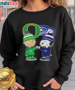 Official Charlie Brown fist bump with Snoopy on Oregon Ducks x Seattle Seahawks sweatshirt, perfect for fans.