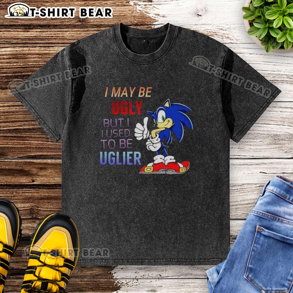 Official I May Be Ugly But I Used To Be Uglier Cartoon Hedgehog Washed T Shirt Cartoon hedgehog on washed T-shirt with 'I May Be Ugly But I Used To Be Uglier' slogan, perfect for quirky fashion.