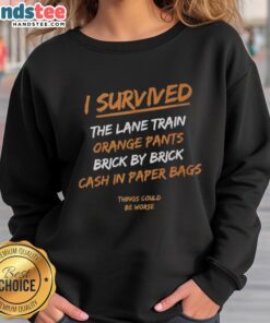 Official I Survived The Lane Train sweatshirt in orange pants, featuring a brick-by-brick cash-in design.