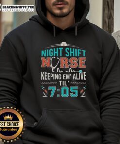 Alt Text: Night shift nurse wearing 'Keeping Em Alive Til 7:05' hoodie, showcasing dedication and care in a healthcare setting.