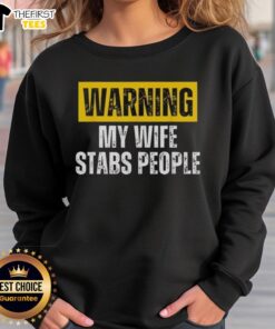 Alt Text: Vintage sweatshirt featuring the phrase Official Warning: My Wife Stabs People in bold letters.