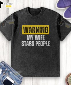 Vintage washed T-shirt featuring 'Official Warning: My Wife Stabs People' graphic, perfect for humorous apparel lovers.