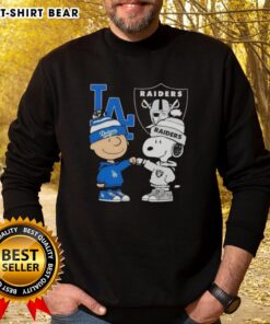Original Charlie Brown fist bump with Snoopy on a Los Angeles sports sweatshirt featuring Dodgers and Raiders logos.