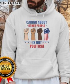 Premium hoodie featuring 'Caring About Other People Is Not Political' design with fists, perfect for social justice advocates.