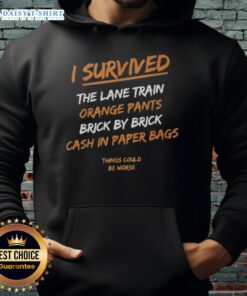 Alt Text: Premium I Survived The Lane Train hoodie with orange pants, featuring a cash-in paper bags graphic, styled brick by brick.