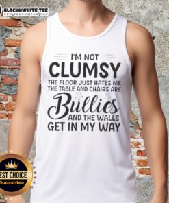 Premium tank top reading 'I'm Not Clumsy, The Floor Hates Me' with a humorous design featuring table and chair graphics.