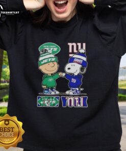 Pretty Charlie Brown fist bump with Snoopy, wearing a New York City Jets vs Giants sweatshirt, showcasing sports spirit.