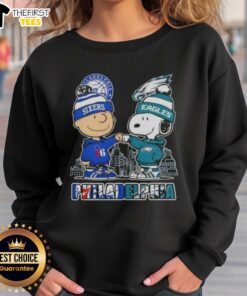 Pretty Charlie Brown fist bump with Snoopy, featuring Philadelphia skyline, 76ers and Eagles logo on cozy sweatshirt.