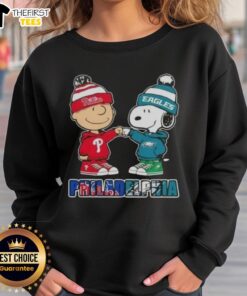 Pretty Charlie Brown fist bump with Snoopy on a Philadelphia sports sweatshirt featuring Phillies and Eagles logos.