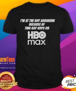 Person wearing 'Pretty I'M At The Boy Aquarium Because Of Two Gay Guys On HBO Max' T-shirt at a vibrant aquarium.